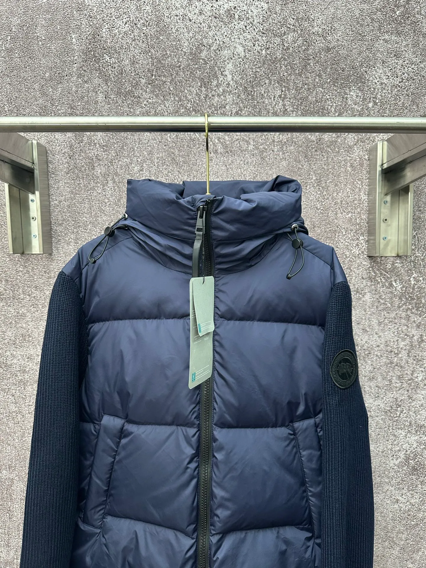P930 Canada Goose Armband Hooded Down Jacket Fabric selection: The use of high-quality protective nylon fabric not only enhances the wear resistance of the surface, but also takes into account wind resistance, ensuring excellent performance in various harsh weather conditions.  90 national standard high-quality white duck down: selected high-loft down, weighing 170g, light and warm, with excellent temperature locking performance and good resilience.  Three-dimensional quilting process: Precision thread reinforcement to prevent velvet drilling and ensure that the fluffy and resilient elasticity lasts as new.  7-needle medium-thick knitted structure: Use thicker yarns to knit woolen fabrics with obvious thickness and weight. The texture is clearly visible and has a rough, retro texture. It has a good skeleton feel, is relatively stiff, and can maintain the silhouette of clothing for a long time. It also provides more layers of still air to lock in heat.  There is a brand exclusive LOGO on the woolen sleeve arms. It is dark and not obvious in the photo.  Accessories: One-to-one customized logo, one-to-one customized zipper pendant, one-to-one customized snap button SIZE: S M L XL